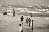 Local people and a beggar on Marina Beach, Chennai, India